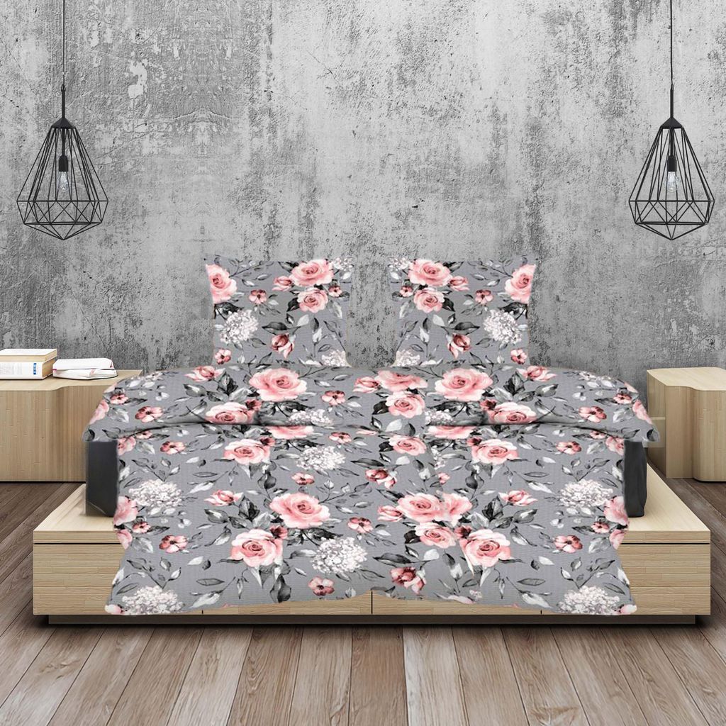A bed with a floral print duvet and pillows, set against a textured gray wall with pendant lights.