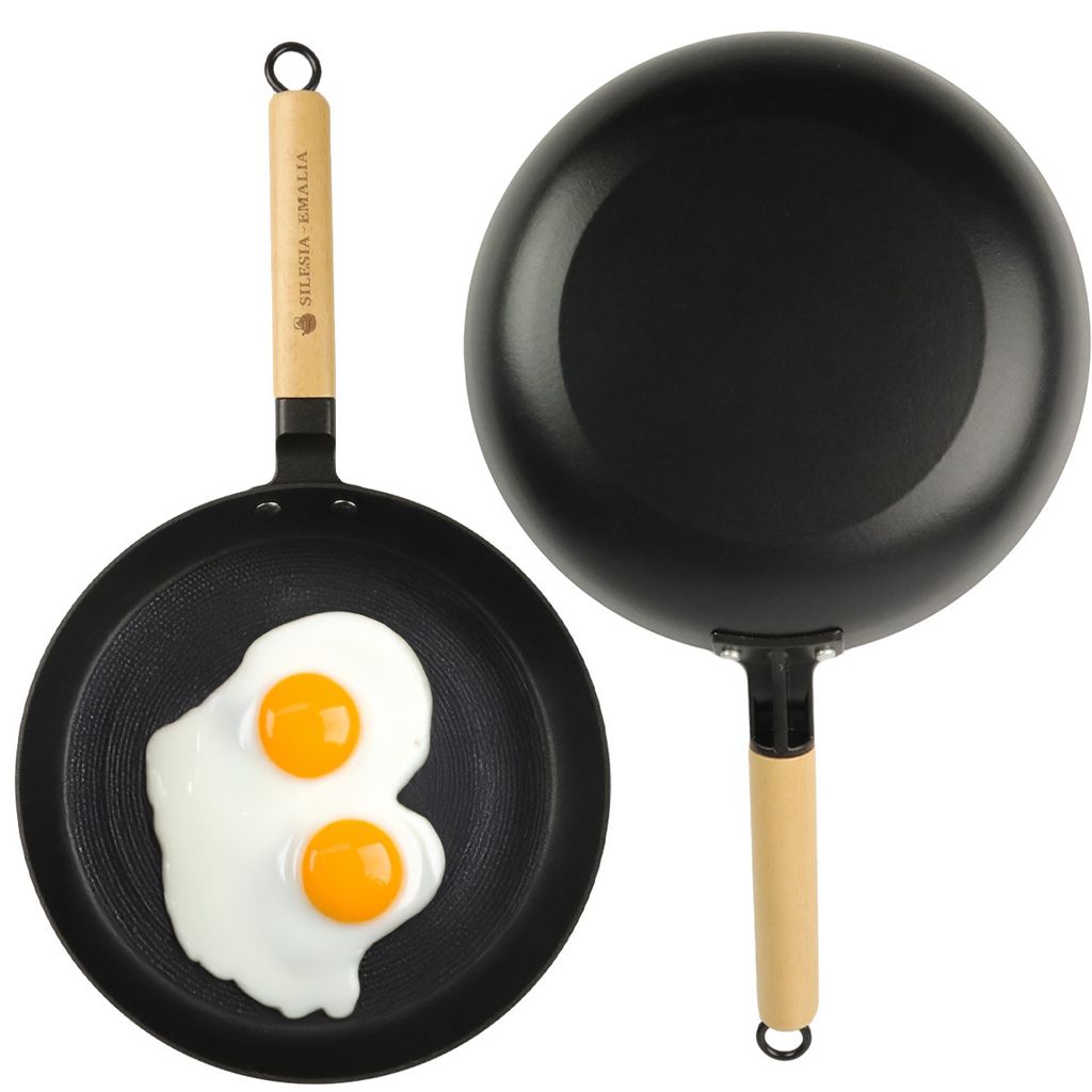 Two frying pans, one with two fried eggs, on a white background.