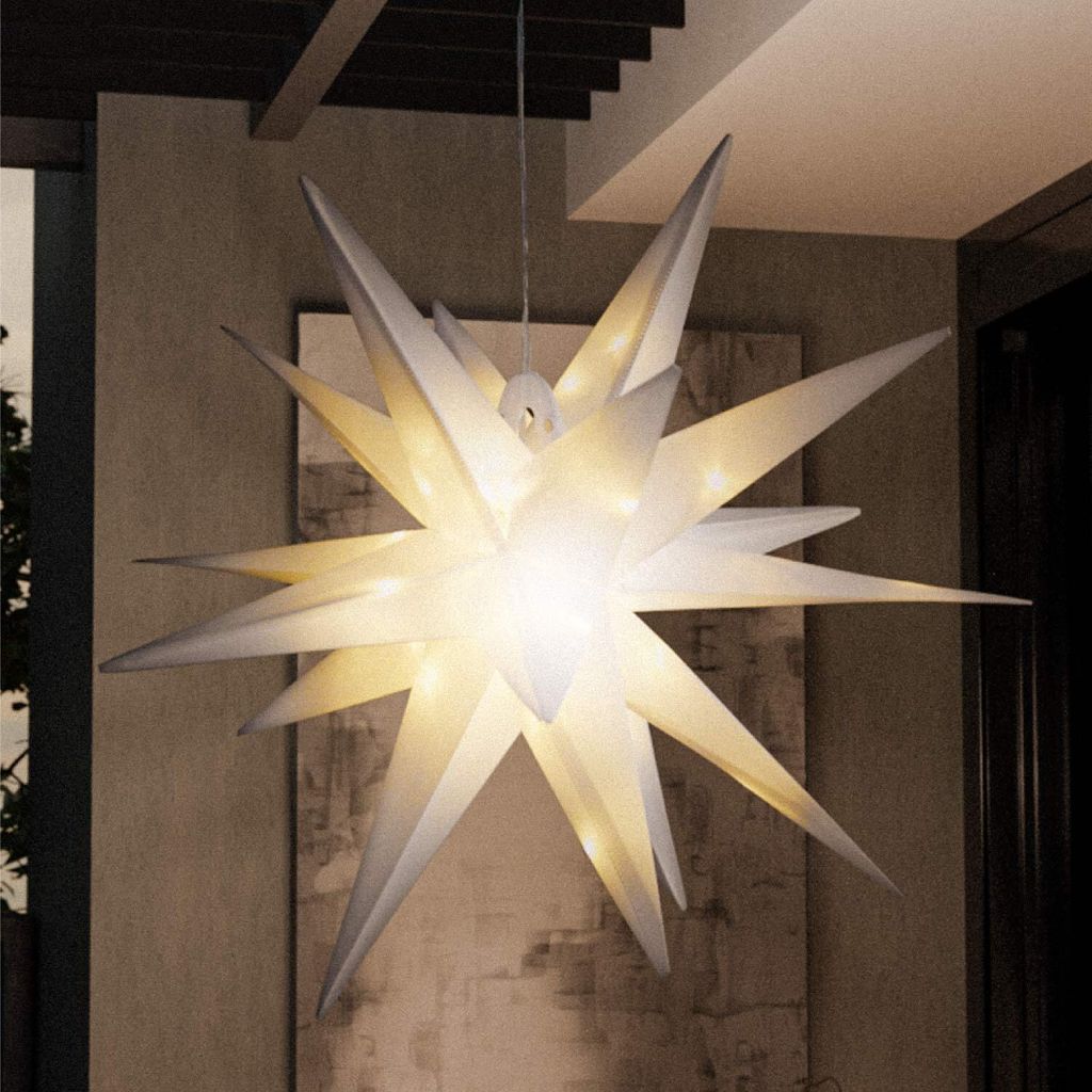A large, illuminated star-shaped lamp hangs from the ceiling in a modern indoor/outdoor space.