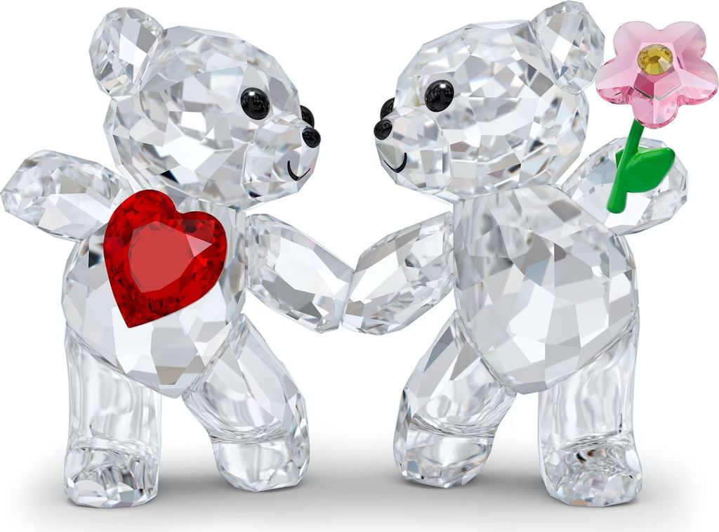 Two crystal teddy bears holding hands, one with a red heart on its chest and the other holding a pink flower.