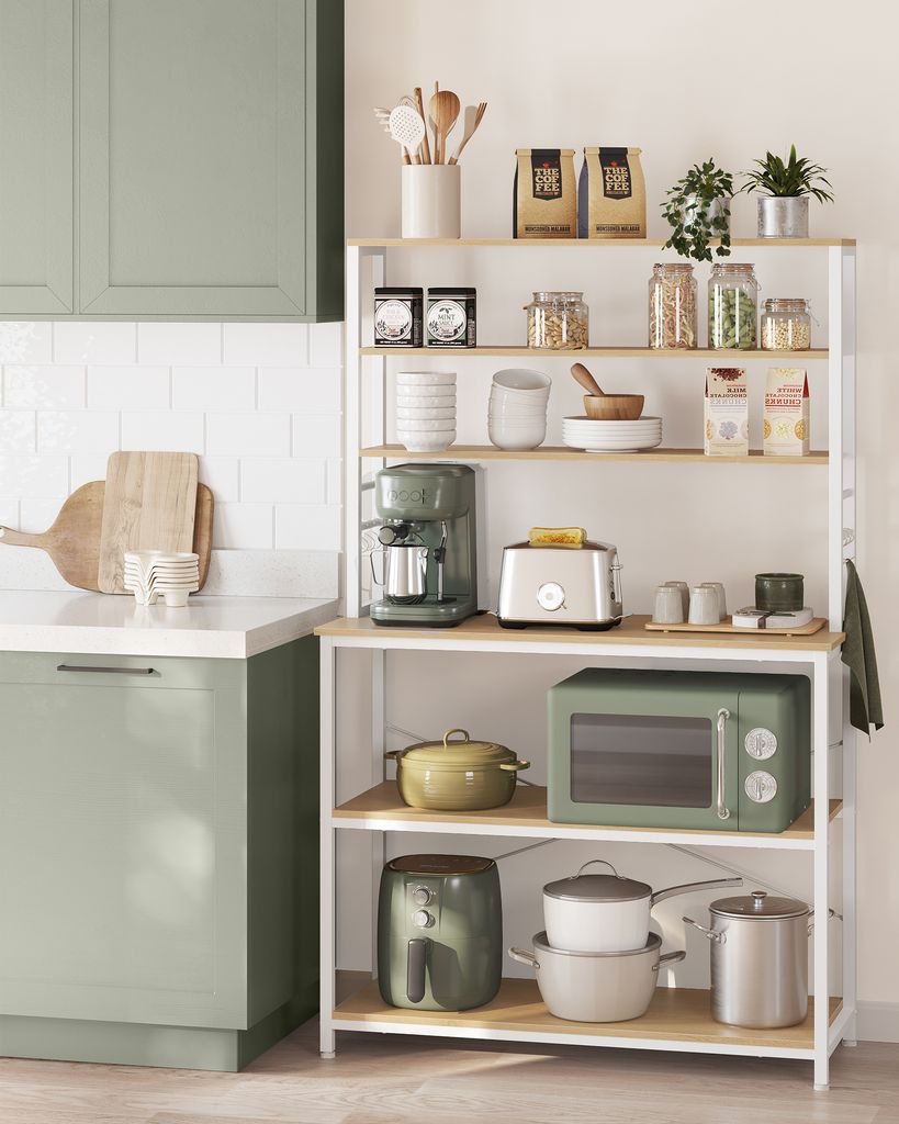 A modern kitchen scene with a white tiled backsplash, sage green cabinets, and a white shelving unit filled with kitchen appliances and decor.