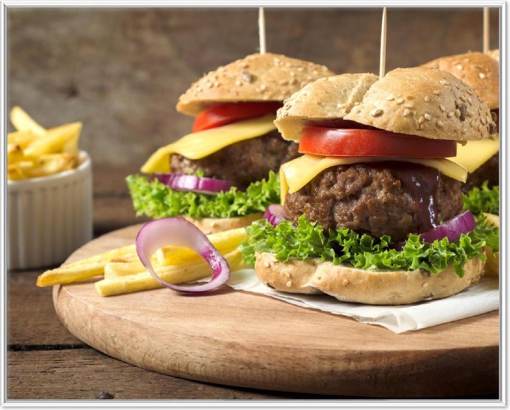 Wallario Wandbild Saftige Burger auf Holzbrett, Größe: 40,30 x 50,30 cm, Poster mit weißem Aluminiumrahmen