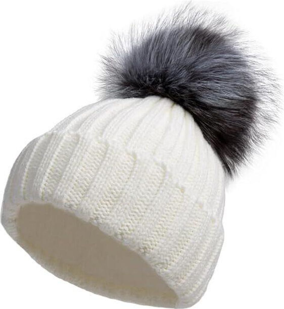 Weiße Strickmütze mit großem flauschigen grau-schwarzen Kunstfell-Pompon oben, aus leichtem Winkel betrachtet