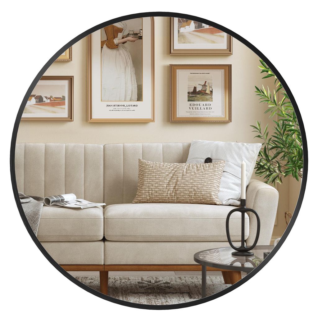 A round mirror reflects a living room scene with a sofa, artwork, and a plant.