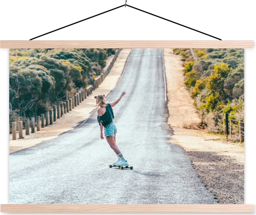 MuchoWow Textilposter Eine Frau auf einem Longboard auf einer asphaltierten Straße 60x40 cm mit holzfarbenen Rahmen - Bilder