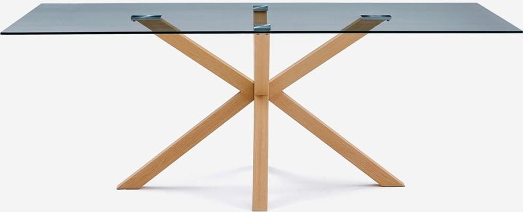 A table with a glass top and wooden legs against a white background.