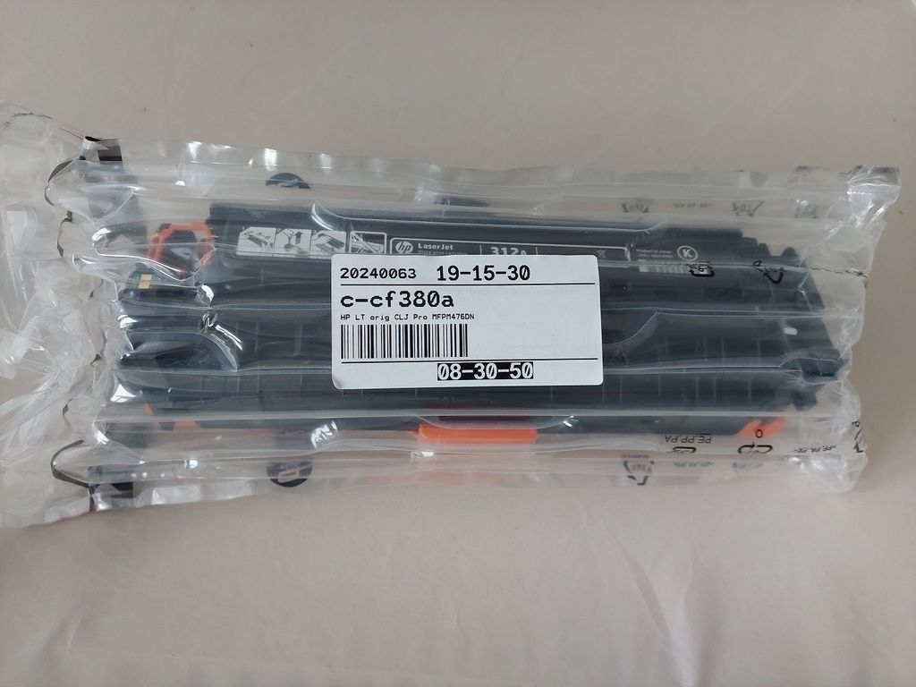 A sealed plastic package containing multiple black toner cartridges.