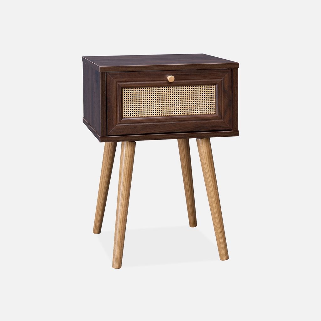 A dark wood bedside table with a rattan drawer front and light wood legs, set against a white background.