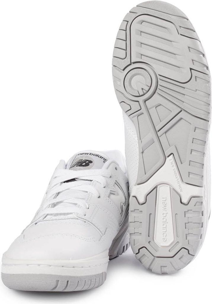 A pair of white New Balance sneakers, with one shoe shown from the side and the other from the sole.