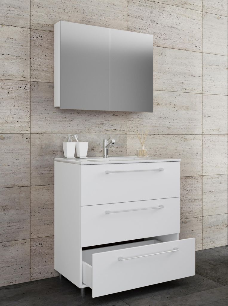 A white bathroom vanity with three drawers and a mirrored cabinet above it, set against a tiled wall.