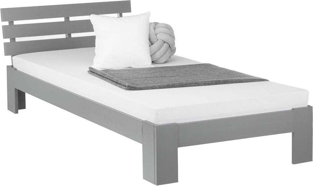 A single bed with a white mattress, a white pillow, and a gray blanket.