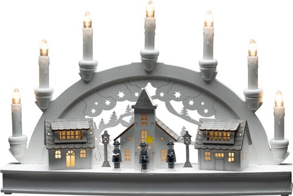 A white LED wooden silhouette of a village scene with houses and a church, illuminated by warm white lights.