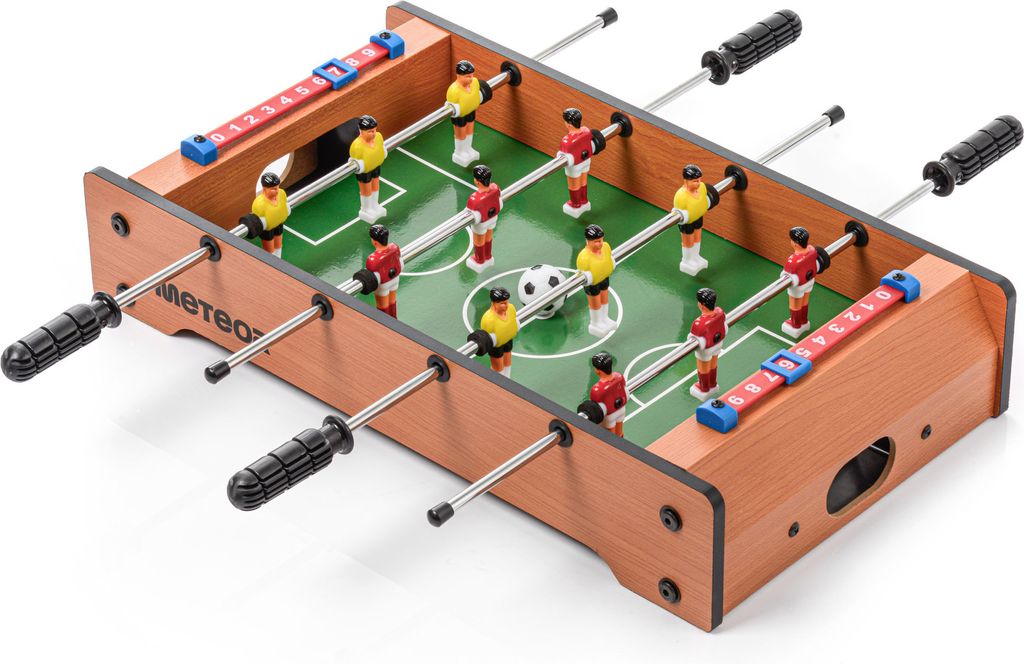 A miniature foosball table with red and yellow players, a soccer ball, and score markers.