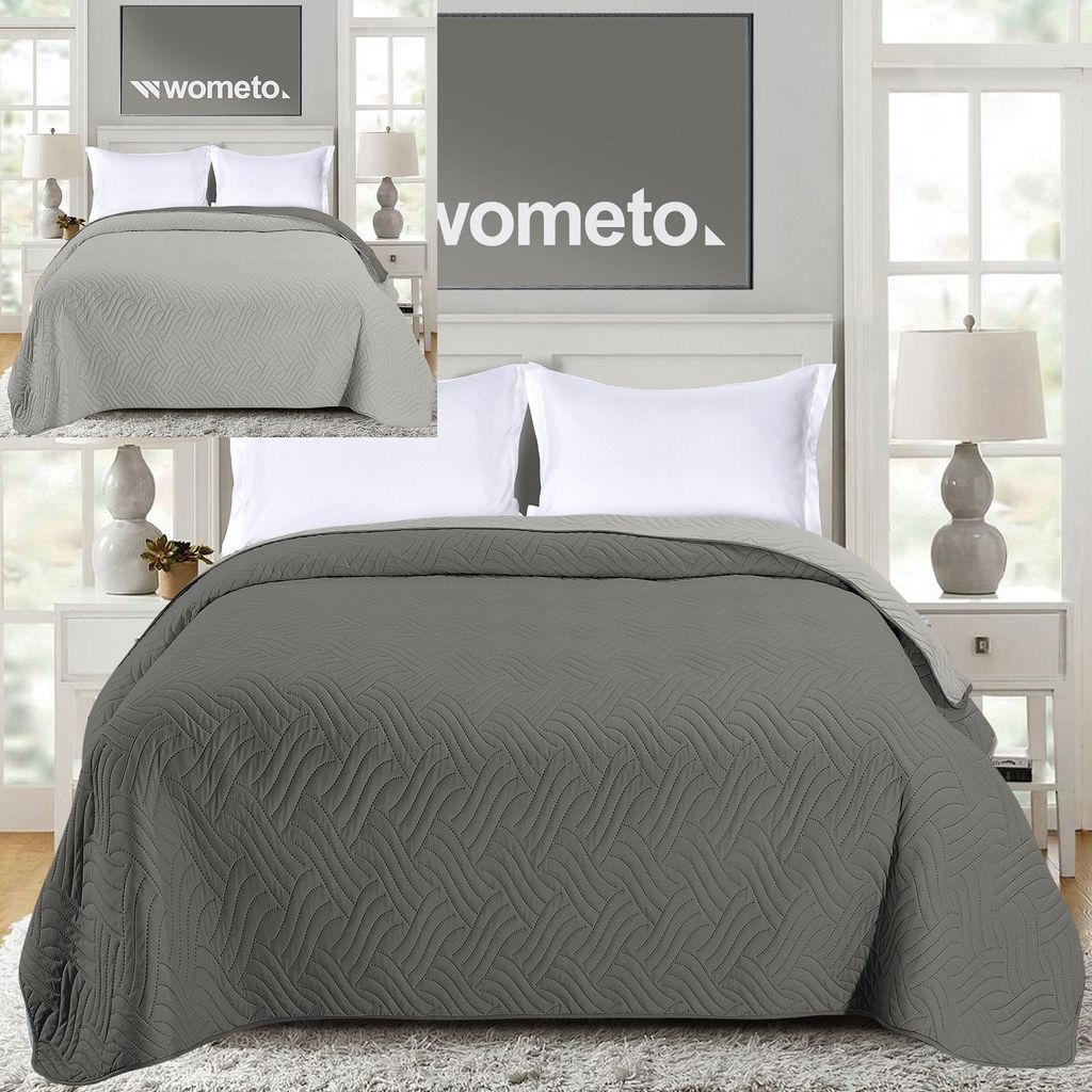 A bedroom setting with a bed and bedding.