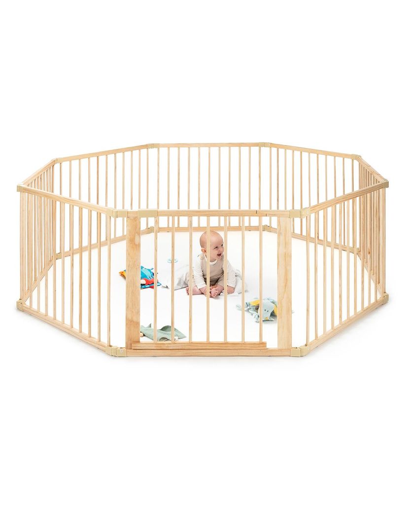 A baby is playing inside a wooden playpen.