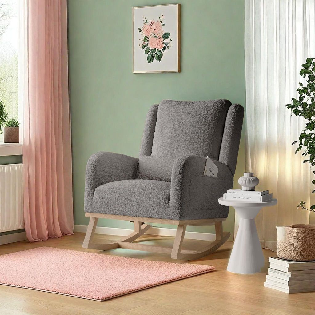 A cozy living room scene with a plush rocking chair, pink rug, and decorative artwork.