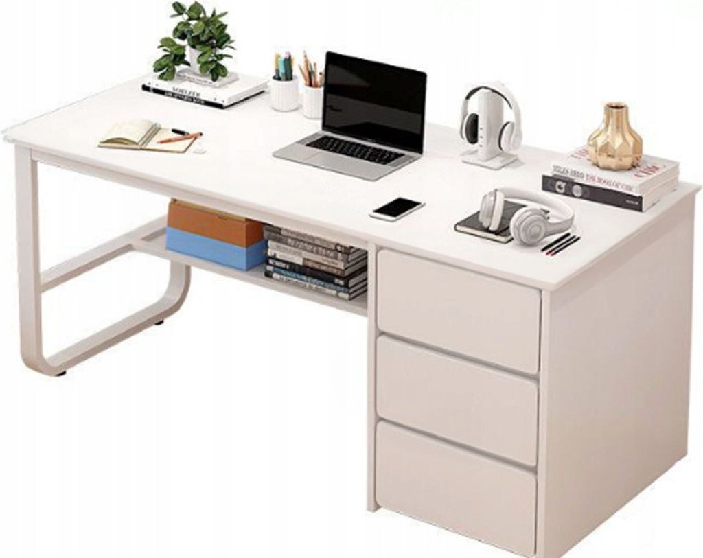 A white desk with a laptop, headphones, books, and a plant.