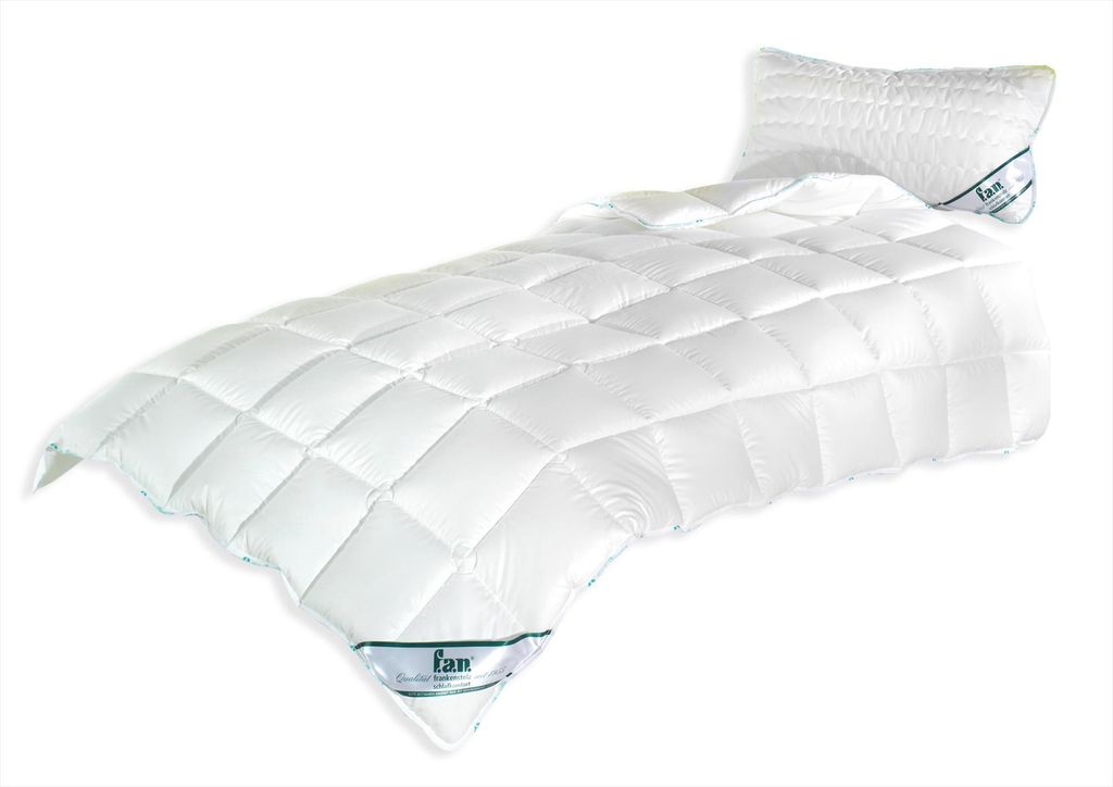 A white quilted comforter and pillow on a white background.