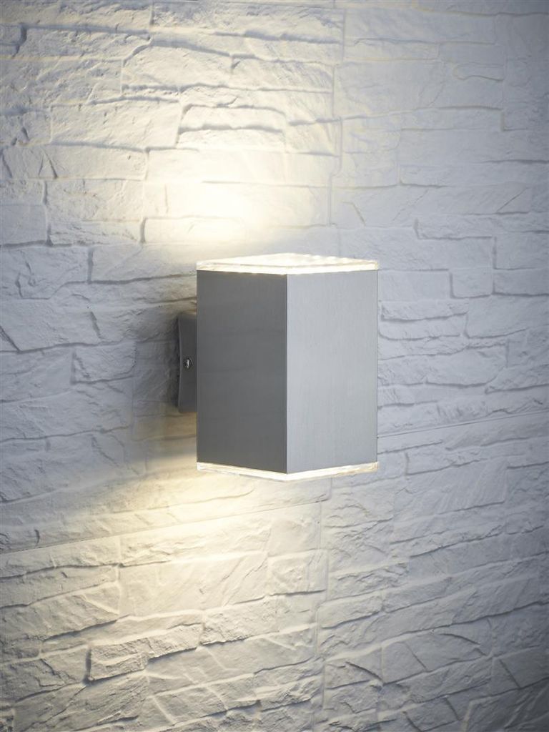 A modern LED wall light mounted on a textured stone wall.