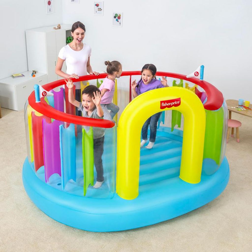 A woman supervises four children playing in a colorful inflatable bouncer.
