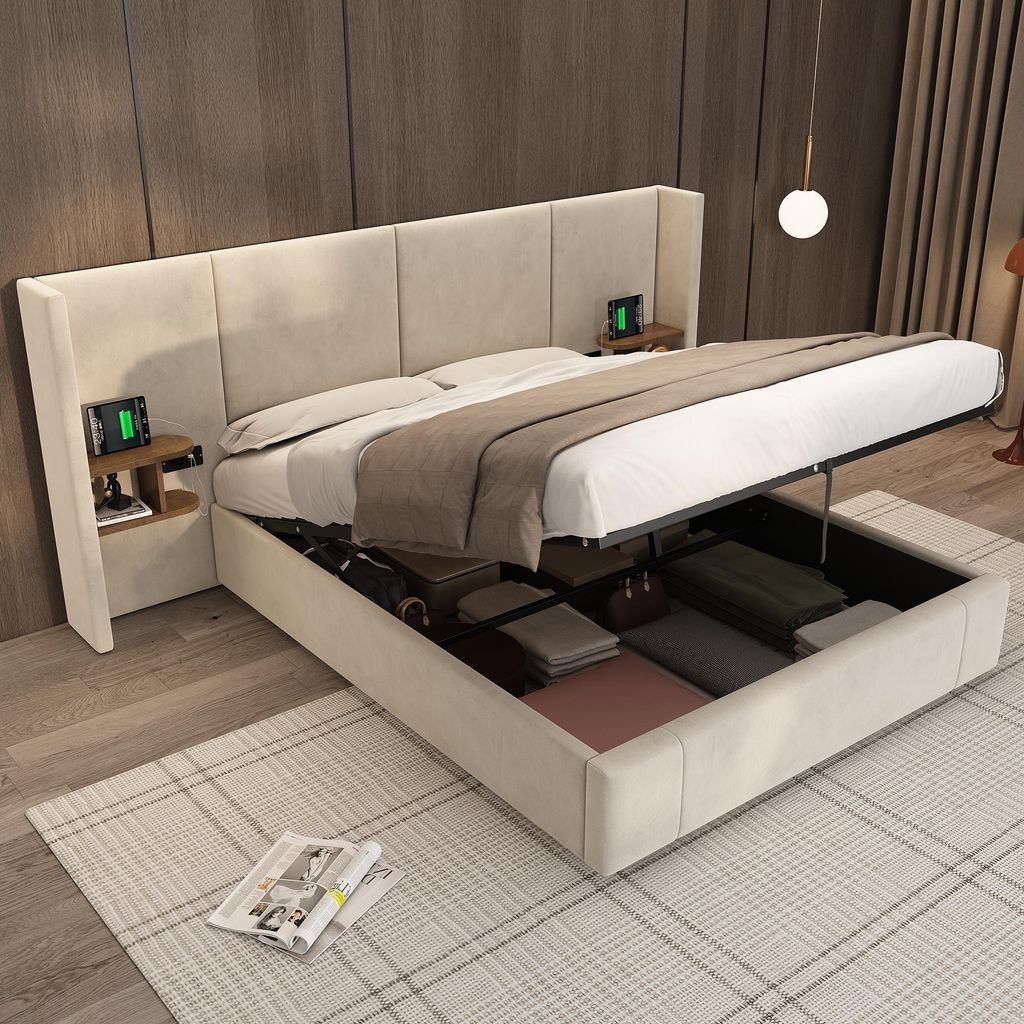 A modern bedroom with a beige upholstered storage bed, open to reveal storage compartments. Two bedside tables with charging devices are attached to the headboard.