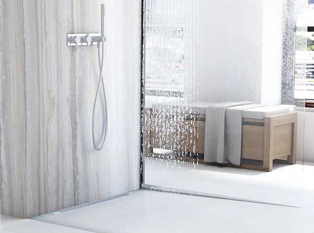 A modern bathroom with a shower, a wooden bench, and a towel.