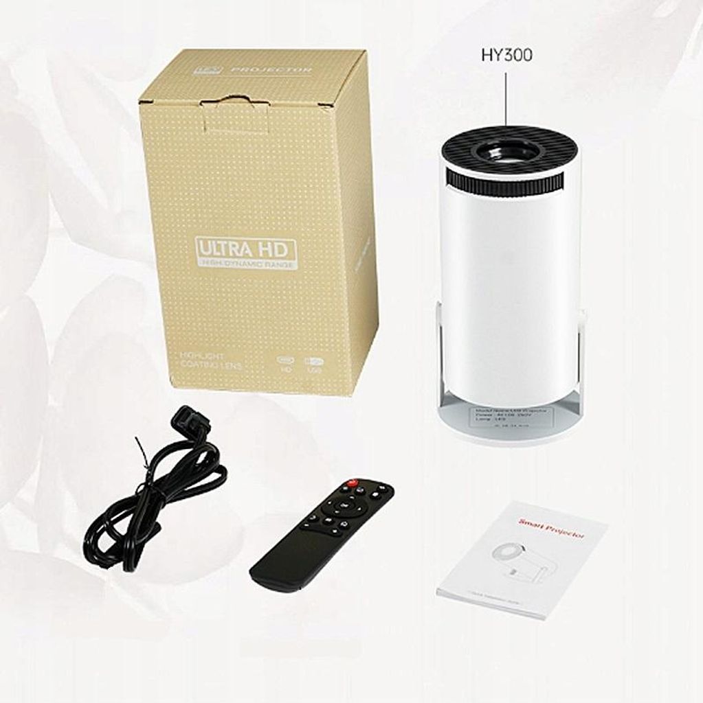 A product shot showing a projector, its packaging, and accessories.