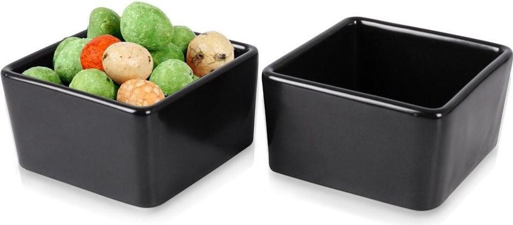 Two black ceramic square bowls, one filled with colorful coated peanuts, the other empty.