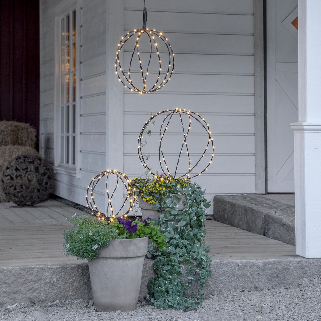Decorative sphere lights on a porch with plants.