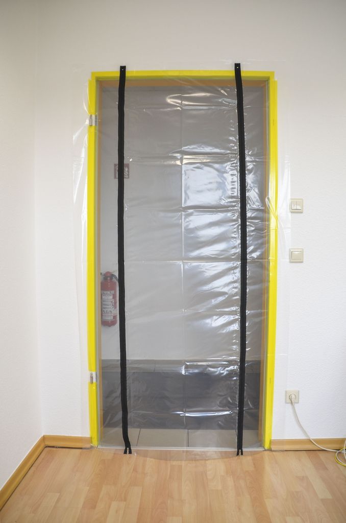 A plastic dust protection door with zippers is installed over a doorway.