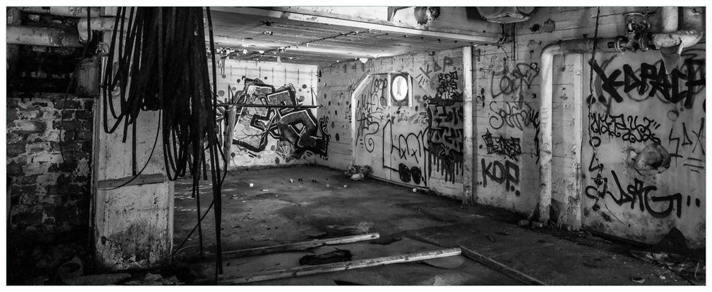 Wallario Wandbild aus Acryl, 200 x 80 cm, freischwebende Optik - Alte verlassene Fabrik in schwarz weiß mit Graffiti