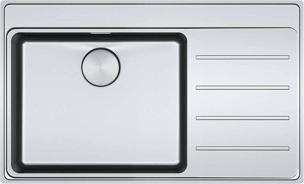 A top-down view of a stainless steel kitchen sink with a drainboard.