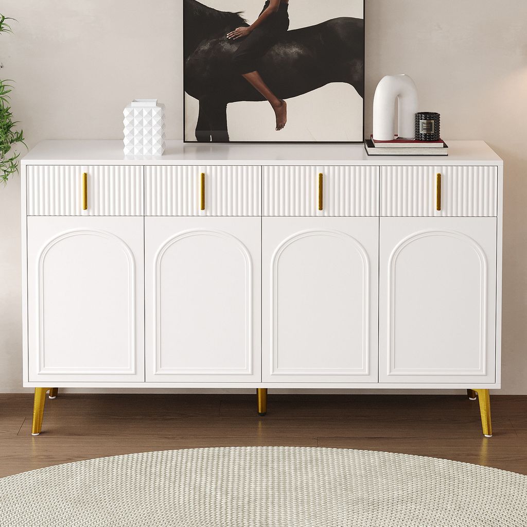 A white sideboard with gold handles and legs, placed in a room with a painting on the wall and a rug on the floor.