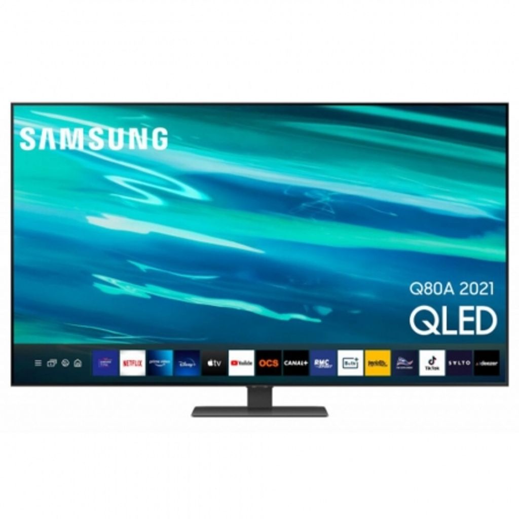 A Samsung QLED smart TV is displayed on a stand against a white background. The TV screen shows a vibrant abstract image with blue and green tones, and a row of app icons is visible at the bottom.