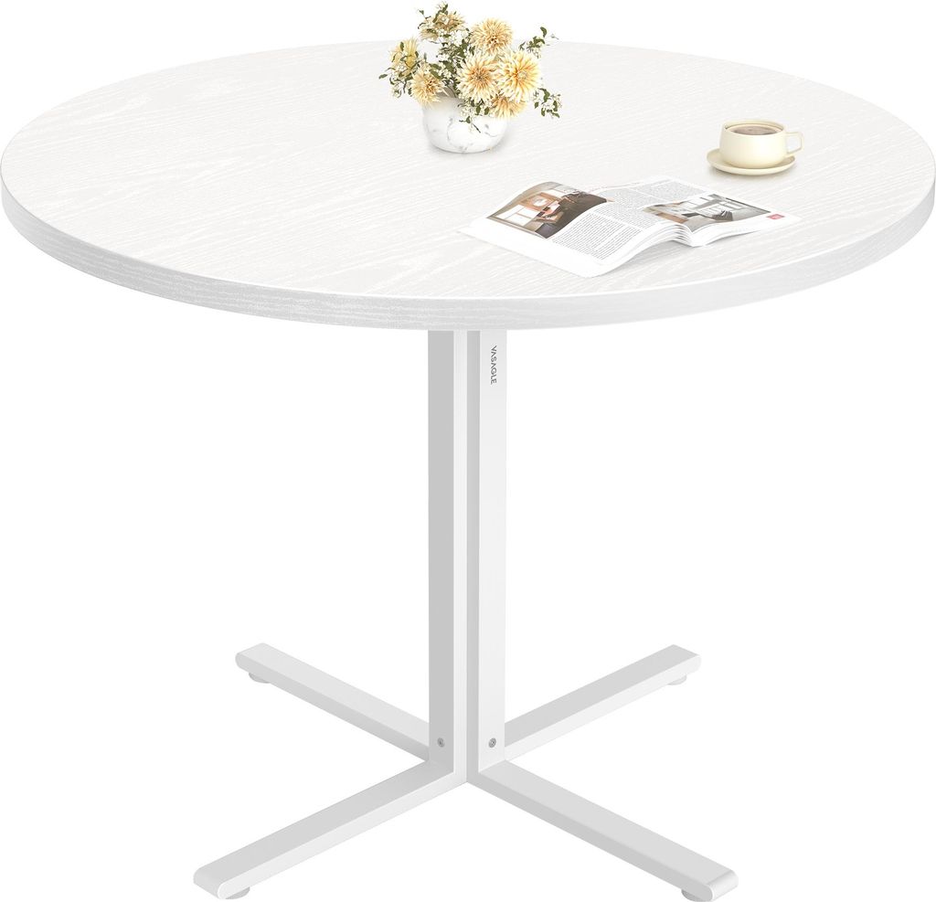 A round white table with a floral arrangement and a book on it.