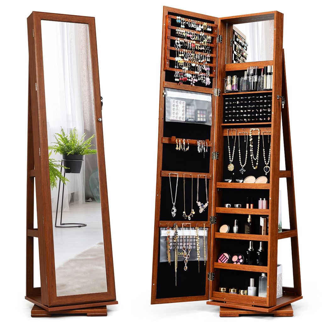 A jewelry cabinet with a full-length mirror is shown open, displaying its interior storage compartments filled with jewelry and cosmetics. The cabinet is made of wood and has a brown finish. The mirror reflects a potted plant and a window.