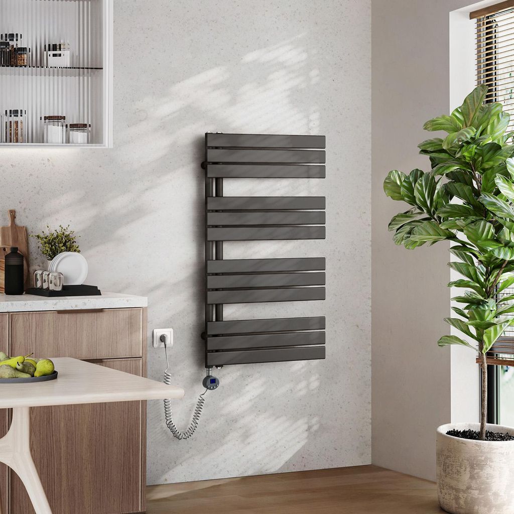 A modern bathroom or kitchen setting with a towel warmer, a plant, and kitchen cabinets.