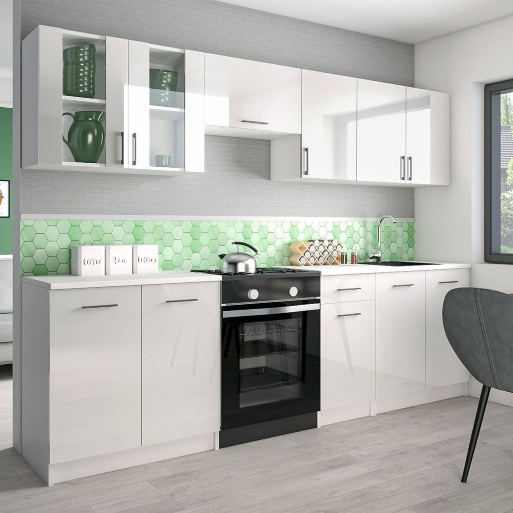 A modern, high-gloss white kitchen unit with a black oven and a green hexagonal backsplash.