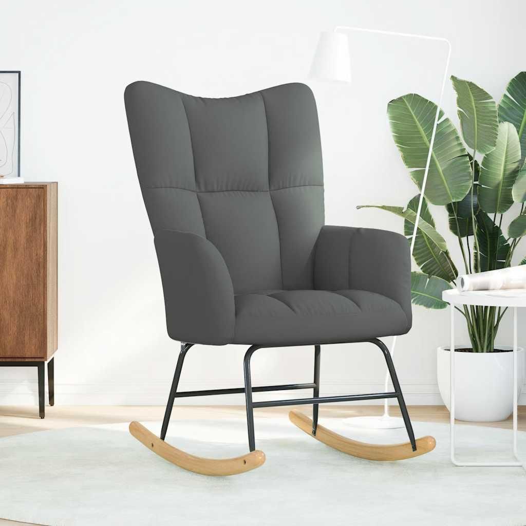 A dark gray rocking chair in a room with a white wall and a wooden cabinet.