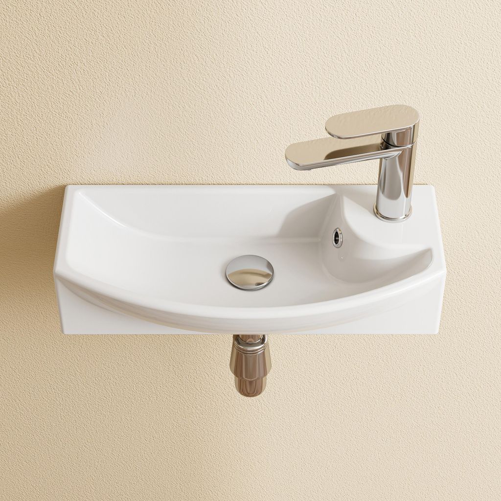 A white ceramic sink with a chrome faucet mounted on a textured beige wall.