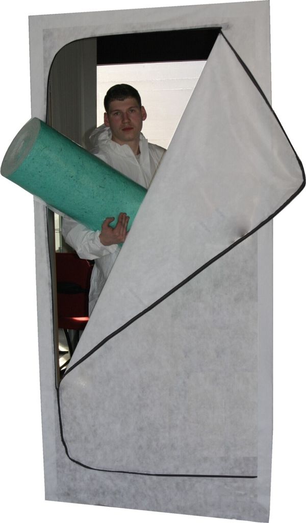 A man in a white protective suit holds a green roll of material inside a white zippered dust protection door.