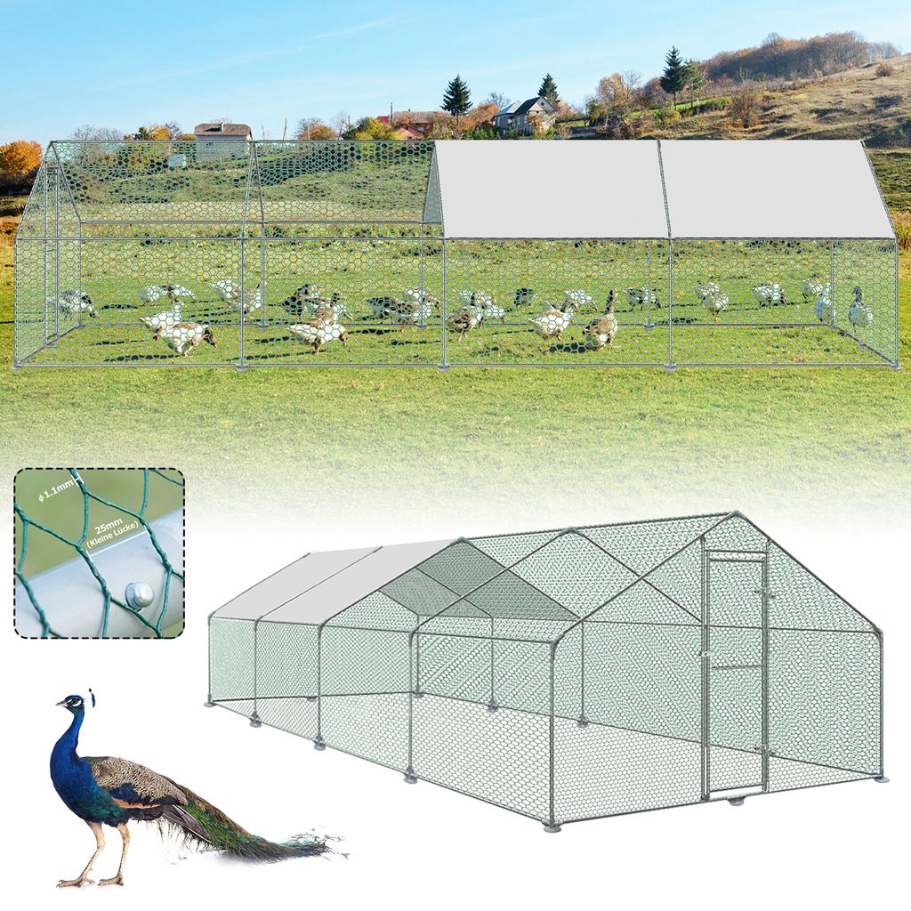 A large outdoor chicken coop with a covered roof section, situated in a grassy field with a few houses in the background. A peacock is shown in the foreground.