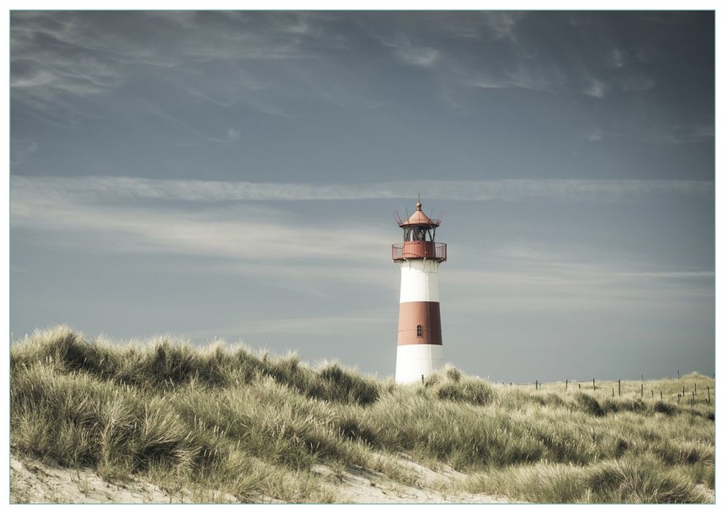 Wallario Premium Glasbild, freischwebende Optik, kräftige Farben, Größe 100 x 70 cm Motiv Leuchtturm auf der Düne am Strand