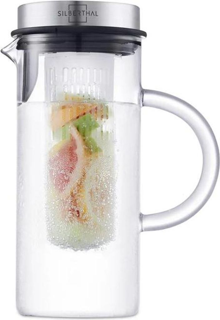 A clear studio shot of a glass pitcher filled with water and fruit.