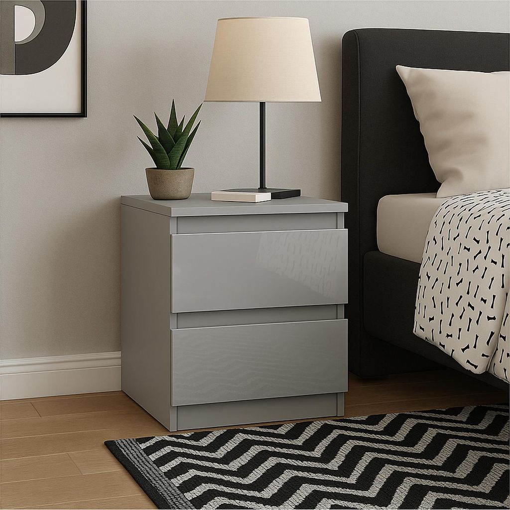 A bedside table with two drawers next to a bed.