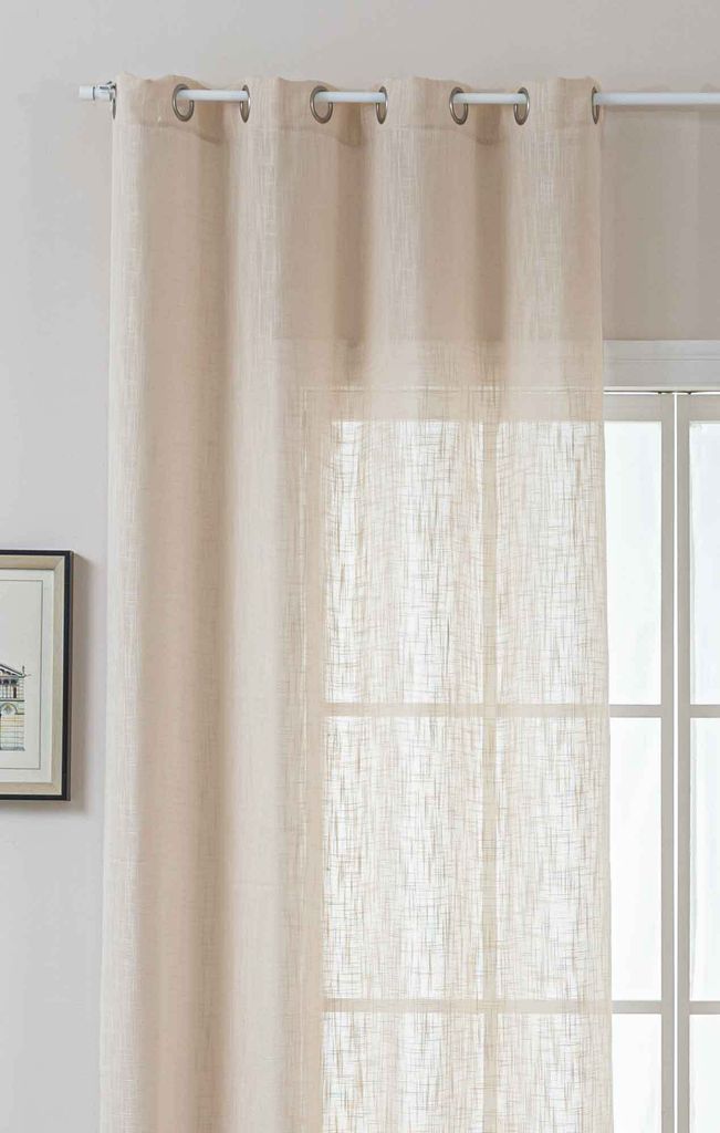 A close-up view of a beige linen-look curtain hanging in front of a window.