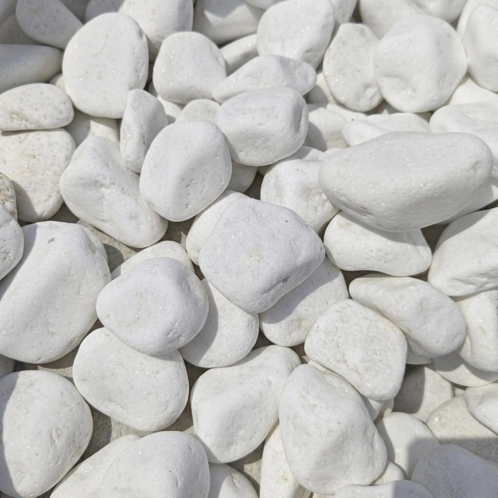 Weiße abgerundete Kieselsteine dicht nebeneinander geordnet als Nahaufnahme