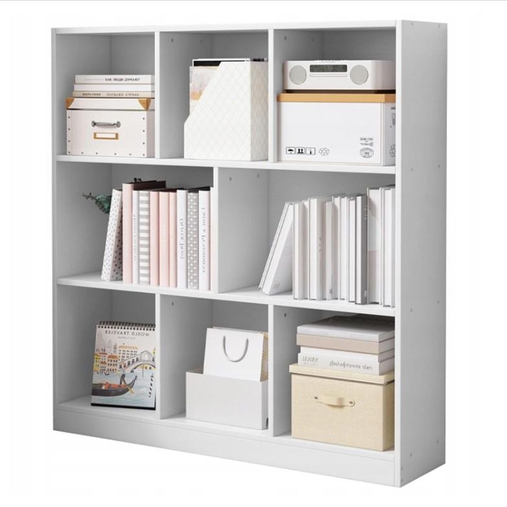 A white, multi-compartment bookshelf filled with books, boxes, and decorative items.
