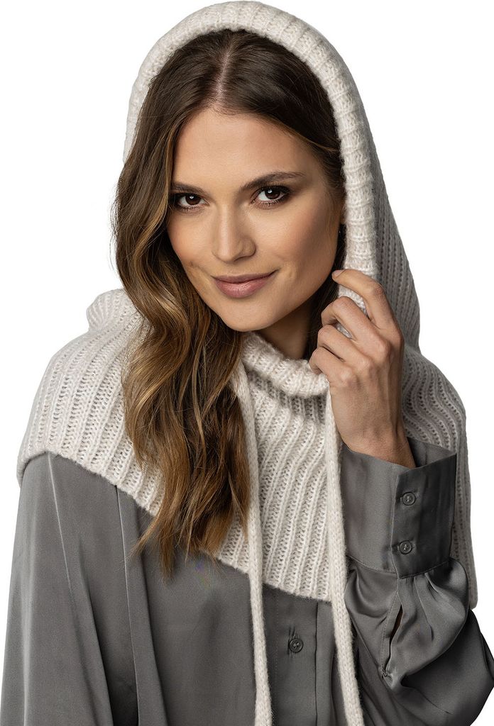 A woman wearing a beige hooded scarf over a gray shirt.