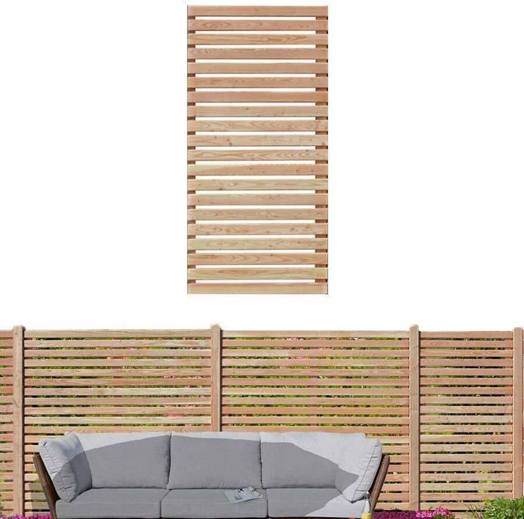 A wooden fence panel is shown above a section of fence with a sofa in front of it.